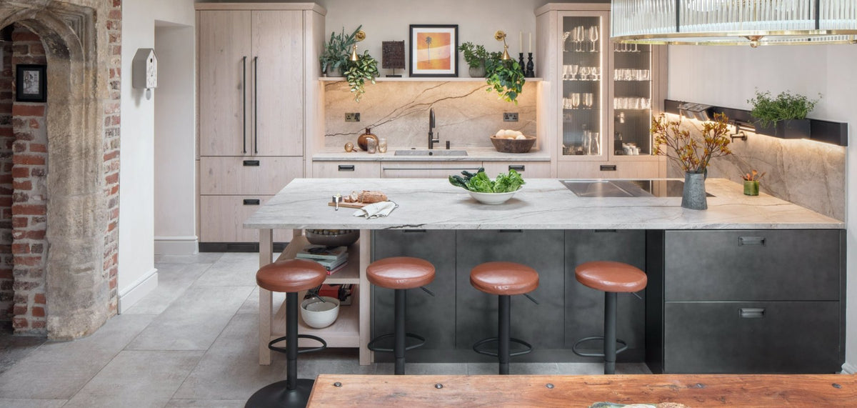 Brani Hadzhi's own kitchen by Multiliving, with a stone-topped island, leather bar stools and an original brick arch